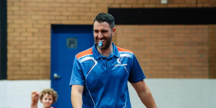 Smiling Soccajoeys franchisee wearing a blue club polo outside a school hall